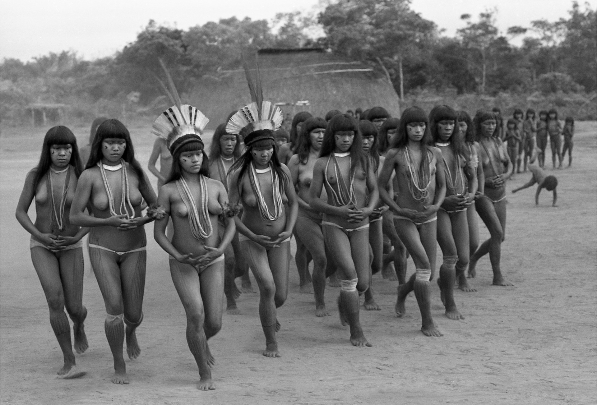 O Yamurikumá é um raro ritual de afirmação feminina numa sociedade patriarcal. Nesse dia de festa as mulheres se enfeitam, cantam, dançam e simbolicamente “tomam conta da aldeia. (Aldeia Ipavu, do povo Kamayurá, Território Indígena do Xingu, Brasil, 1973)
